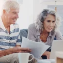 Senior couple reviewing retirement planning steps with a checklist